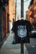Still ice drip black graphic tee hanging on street pole