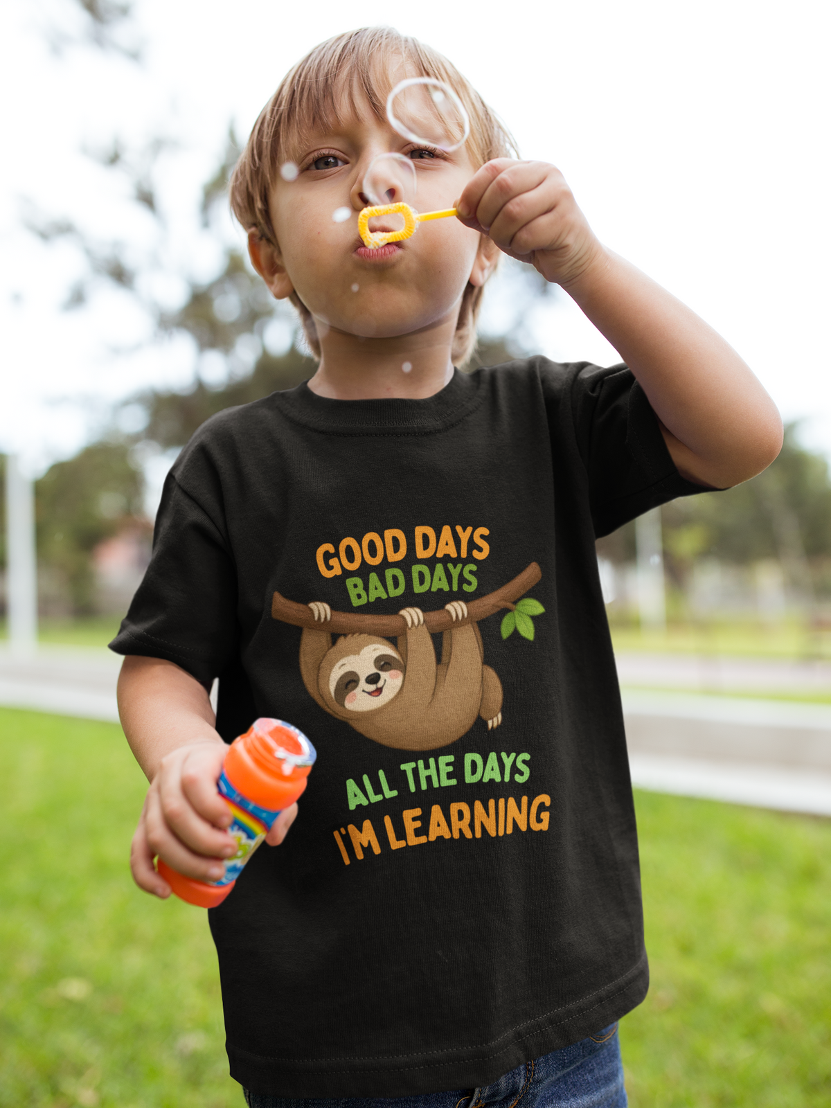 Mini Learning Sloth Tee Black - boy blowing bubbles