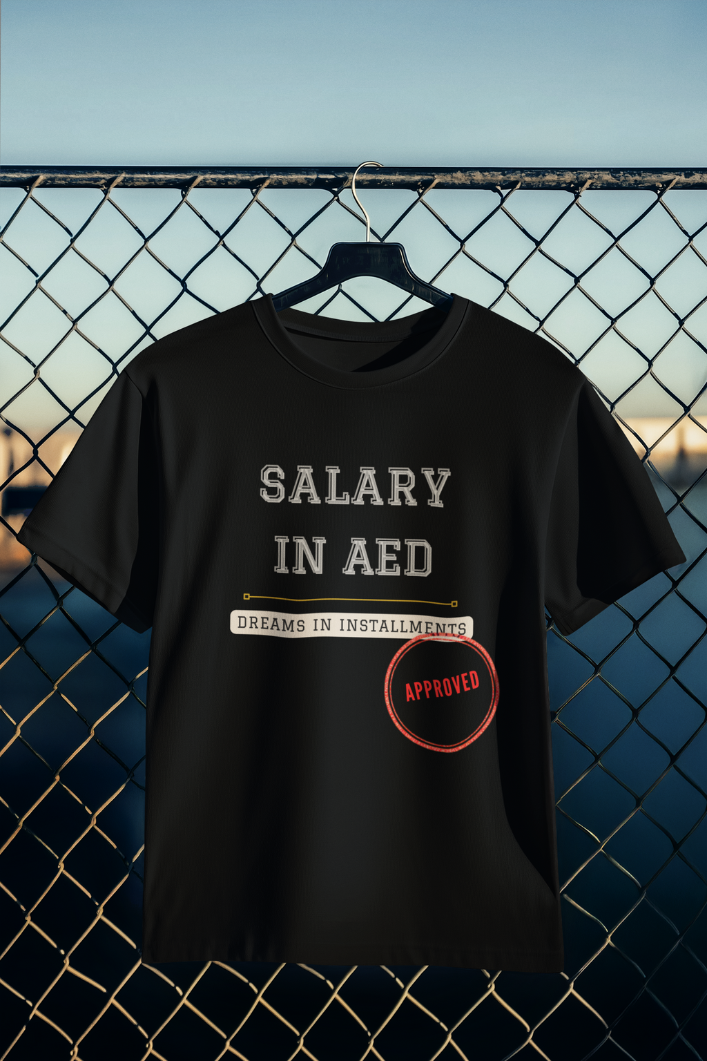 Salary in AED Dreams in Installments black tee hanging on wire fence