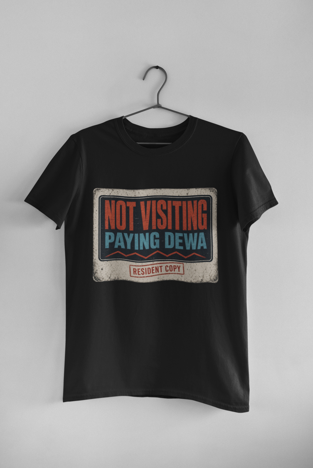 Not Visiting Paying DEWA white unisex tee hanging on wall