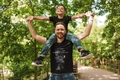 School Run Then Everything Else black tee dad carrying son on shoulders park