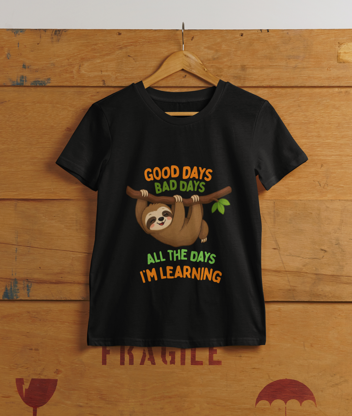 Mini Learning Sloth Tee Black - hanging on cargo box