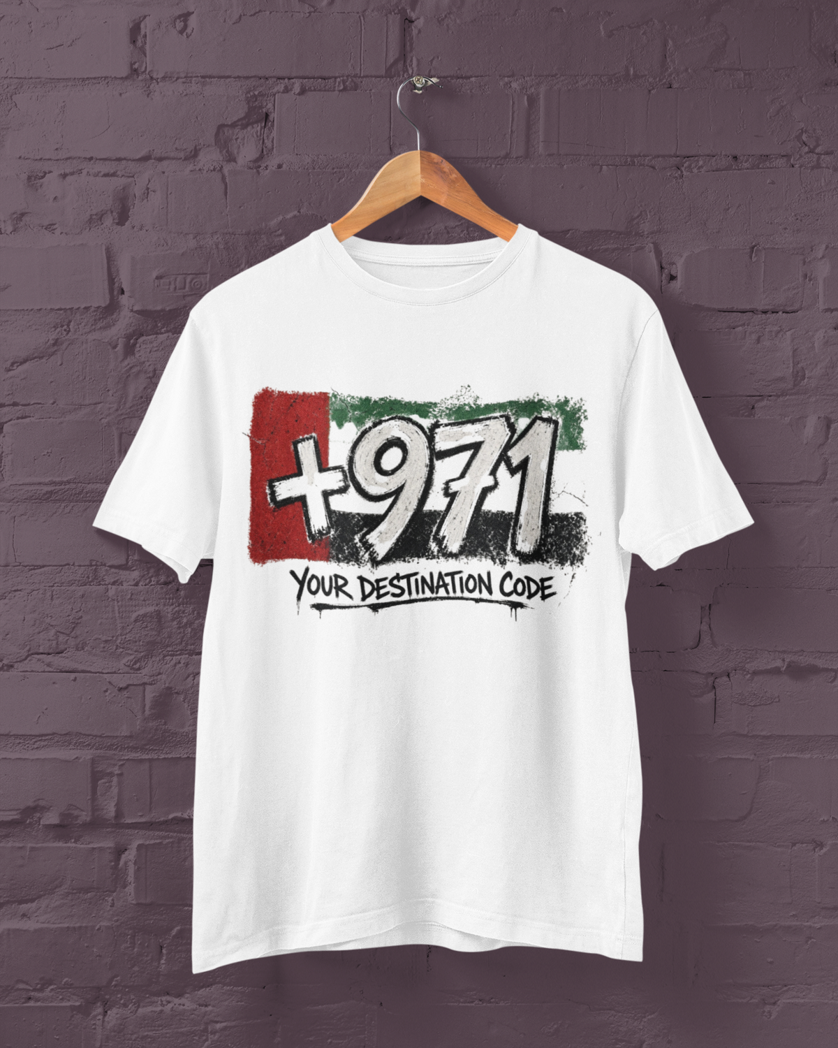 White T-shirt on a hanger showing the +971 Your Destination Code graphic in UAE-inspired colours.