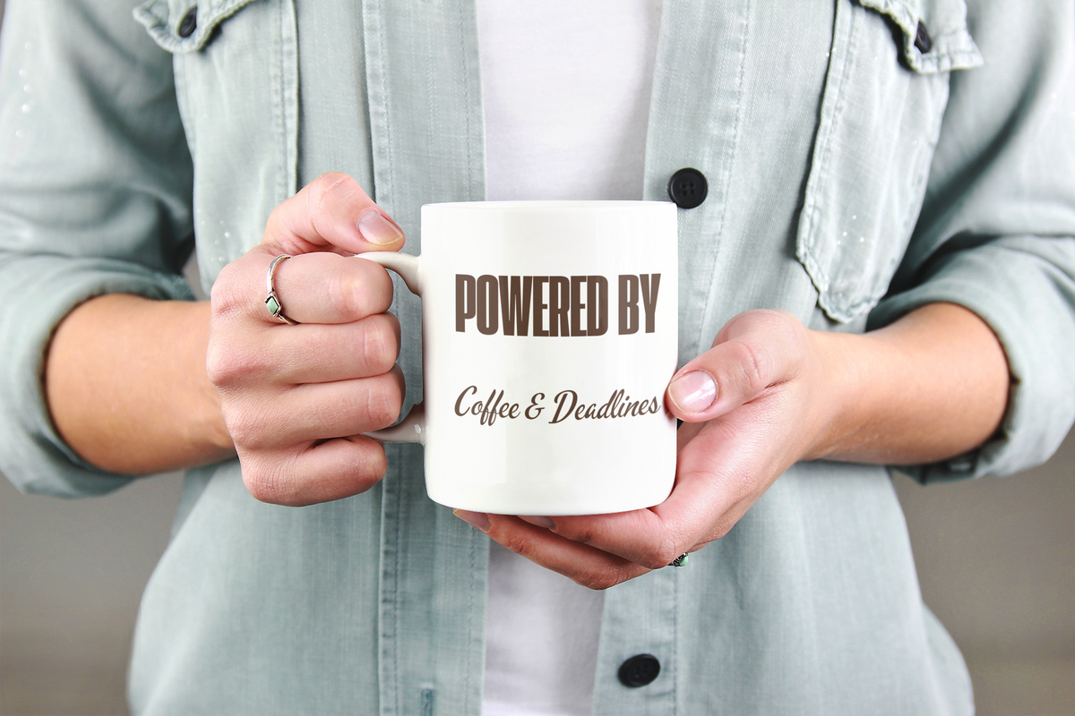 Powered by Coffee & Deadlines Mug - woman holding white ceramic mug